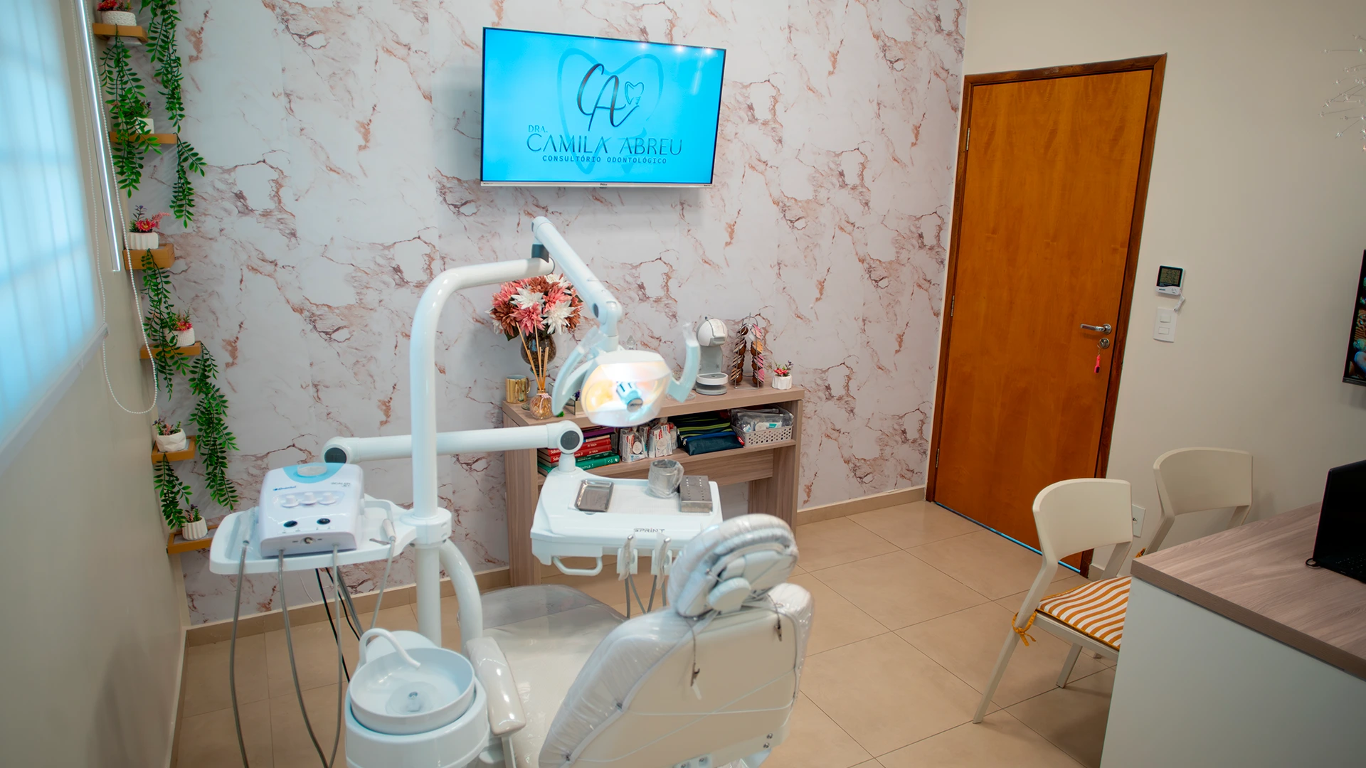 Sala de atendimento da Dra. Camila Abreu, com cadeira odontológica e sem pacientes.